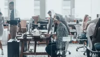 People working at desks and stood around desks