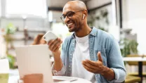 Man working remotely using PC and phone in a cafe