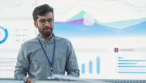 man in front of a large display training people about cyber security.