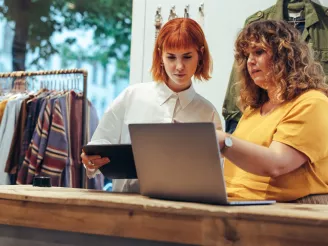 Women using a tablet in a fashion retail shop