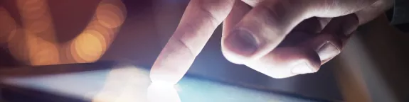 A finger toughing a screen