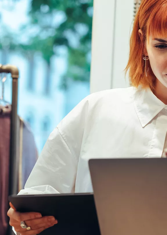 Women using a tablet in a small fashion retail shop