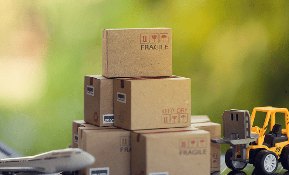 A stack of boxes next to a plane and a truck