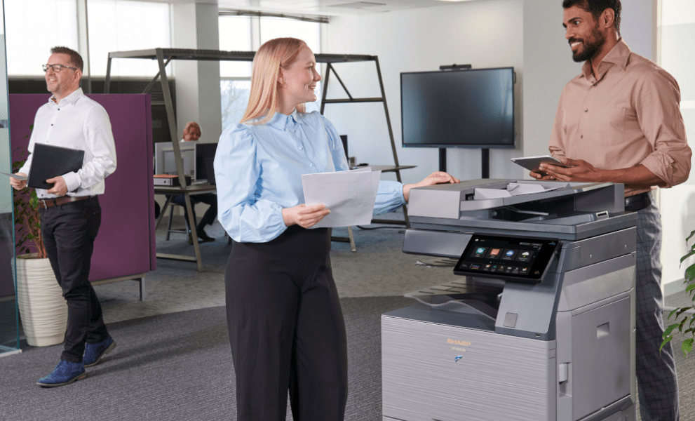 Colleagues talking at office printer